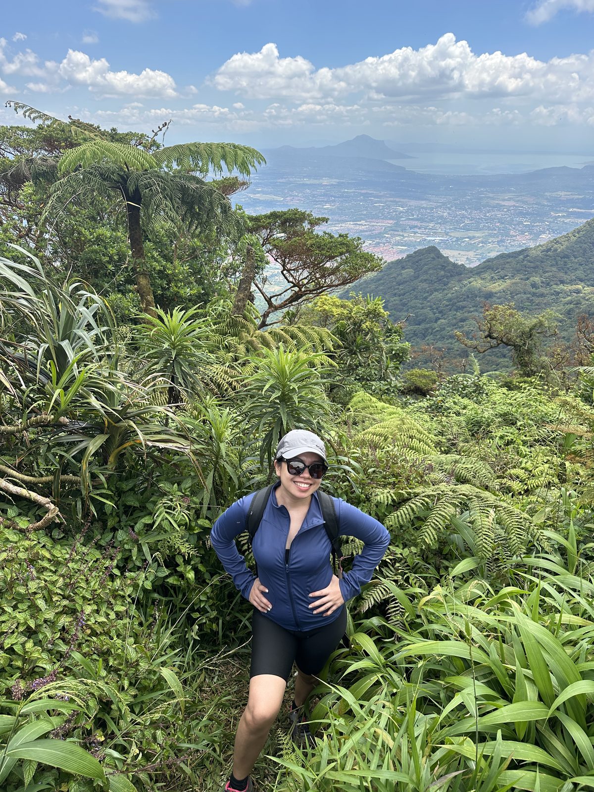 Pam posing on the trail at Mt. Makiling with the valley view behind her