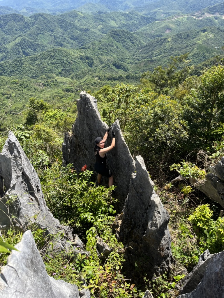Pam climbing between limestone rock formations
