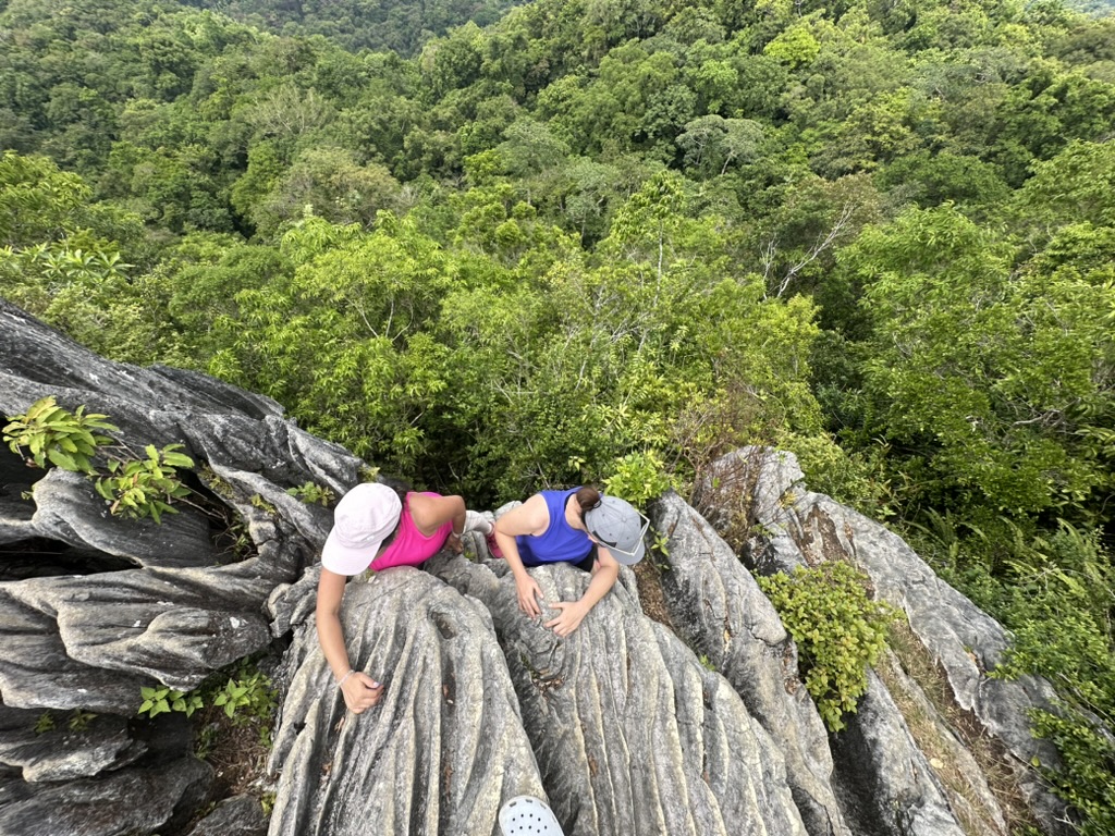Pam and a friend resting on a rocky ridge in the forest