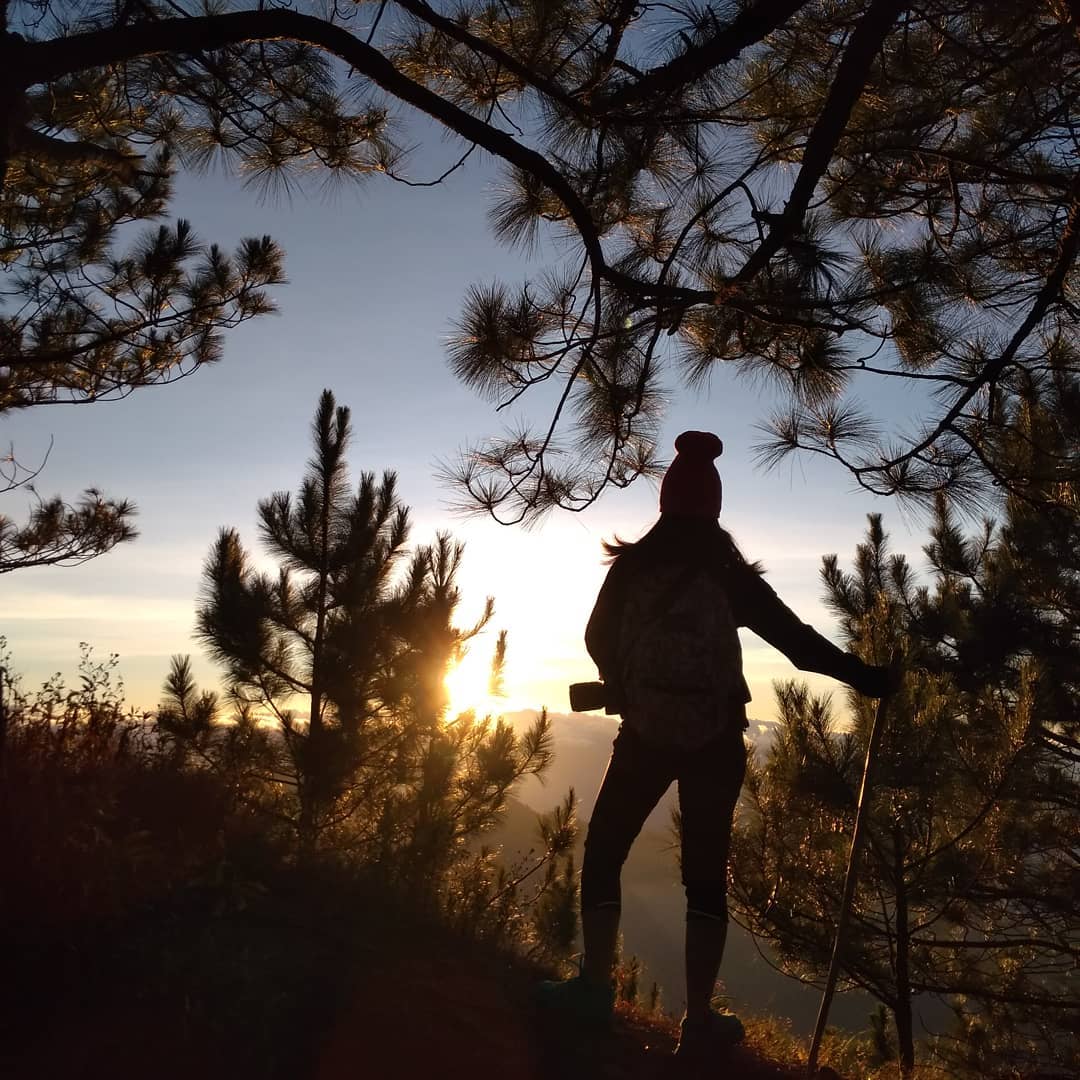 Silhouette of Pam watching the sunrise on a hiking trail